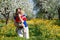 Family in apple orchard in bloom and dandelion field