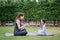 Family Asian Mother teacher training yoga child daughter on a yoga mat at home garden. Family outdoors. Parent with child spends