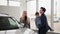 family auto purchase, happy wife, together with her husband and son in their arms, choose a new model of family car in a