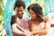 Family With Baby Relaxing On Outdoor Garden Swing Seat