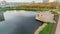 Family with baby rests on pier over pond with bathing ducks