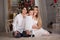 A family with a baby sits sitting near the Christmas tree