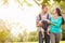 Family With Baby Son In Carrier Walking Through Park