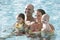 Family with baby and toddler in swimming pool