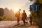 Family backpackers goes on road at sunset