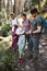 Family with backpacks hiking in a mountains actively spending summer vacation together