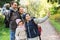 Family with backpacks taking selfie by smartphone