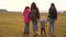Family with backpacks travels with a dog. teamwork of a close-knit family. Mother, daughters and home pets tourists