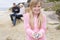 Family at beach with picnic and girl with shell