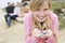 Family at beach with picnic and girl with shell