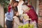 Family Being Greeted By Grandparents As They Arrive For Visit On Christmas Day With Gifts