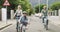 Family, bicycle and cycling together with child and grandparents on neighborhood street for fun, exercise and adventure