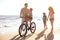 Family with bicycle on sandy beach near sea