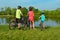 Family on bikes outdoors, active parents and kid cycling and relaxing near beautiful river, fitness