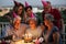 Family birthday celebration in friendship by night - group of different ages caucasian people enojy celebration with cake and