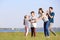 Family blowing soap bubbles near river on summer day