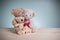 Family brown teddy bears hug happy front side have wood house models and red hearts on an old wooden table with copy space.