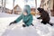 A family builds a slide in the yard in winter.