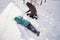 A family builds a slide in the yard in winter.