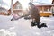 A family builds a snowman out of snow in the yard in winter.