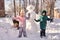 A family builds a snowman out of white snow in the yard in winter.