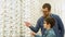 Family buy glasses. Father and son in a blue shirts choosing glasses