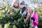 Family buying Christmas tree on market