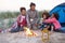 Family Camping On Beach And Toasting Marshmallows