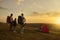 Family camping in mountains. Parents and child with backpacks enjoying beautiful sunset at campground, copy space