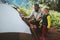 Family camping outdoor child helps to set tent father and daughter travel together hiking vacations