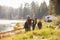 Family on a camping trip walking near a lake looking away