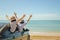 Family car trip at the sea, Woman and child cheerful raising their hands up and feeling happiness.