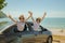 Family car trip at the sea, Woman and child cheerful raising their hands up and feeling happiness.