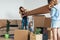 Family with cardboard boxes in new house at moving day