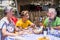 Family caucasian people with grandmother grandfather grandson eating together in alternative natural place restaurant enjoying the