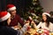 A family celebrate Christmas time together with dinner and sparkling during dinner - focus at sparkler