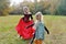 The family celebrates Halloween. Mom in the form of a vampire, girls in the form of a cheerleader and a pumpkin. Mom