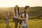 Family with a child with backpacks on a walk in nature at sunset.