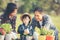 Family child girl helping parent care plant flower in garden. Young people mother, father and daughter gardening