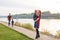 Family and children concept - mother, father and two sons enjoying the summer time, playing near the river