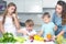 Family with children cut vegetables for cooking