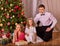 Family with children dressing Christmas tree.