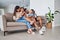 Family, children and laugh with a girl, sister and parents sitting on a sofa in the home living room together. Kids