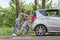 Family with children pushing a faulty car