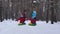 Family with children relaxing on Christmas holiday while riding snow sauser and laughing. Dad mom and daughters ride on