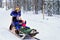 Family with children riding husky dogs sledge in Lapland