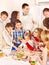 Family and children rolling dough in the kitchen.