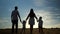 Family with children stands joining and raising hands