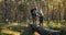 Family with children walking on fallen tree in forest