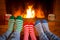 Family in Christmas socks near fireplace